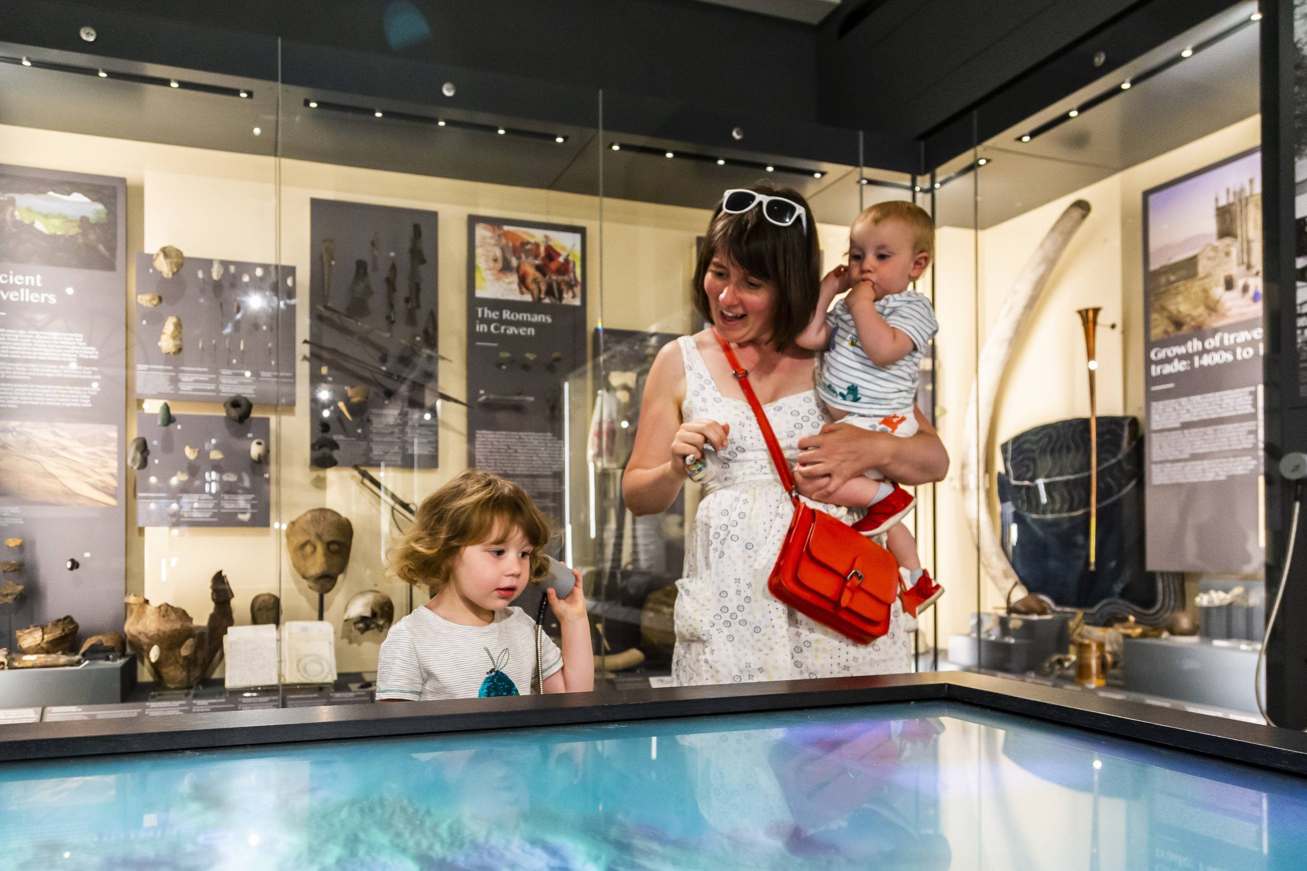 Mother with two children using an interactive display in the museum